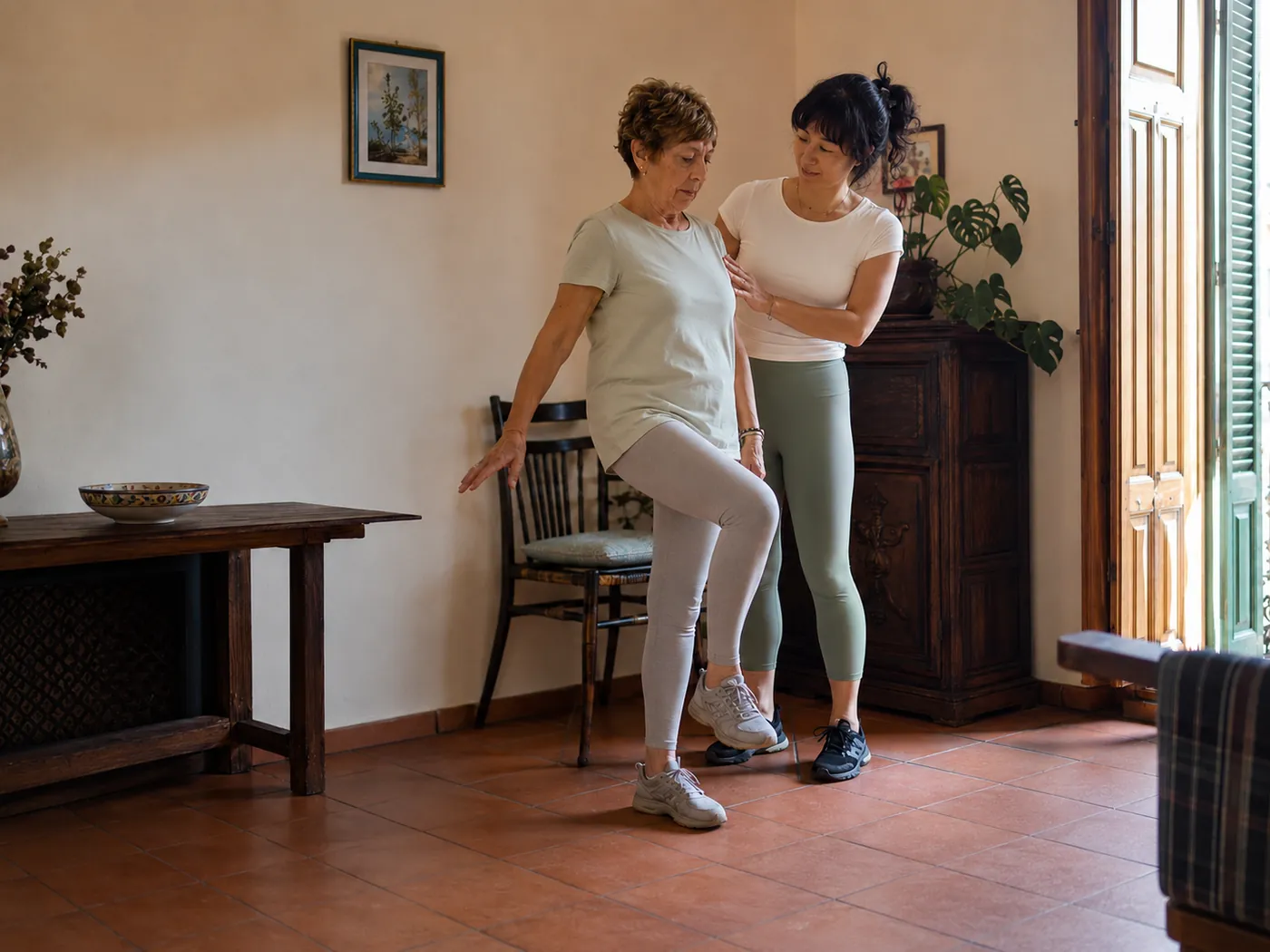 Julie guiding a client through a balance exercise during recovery training